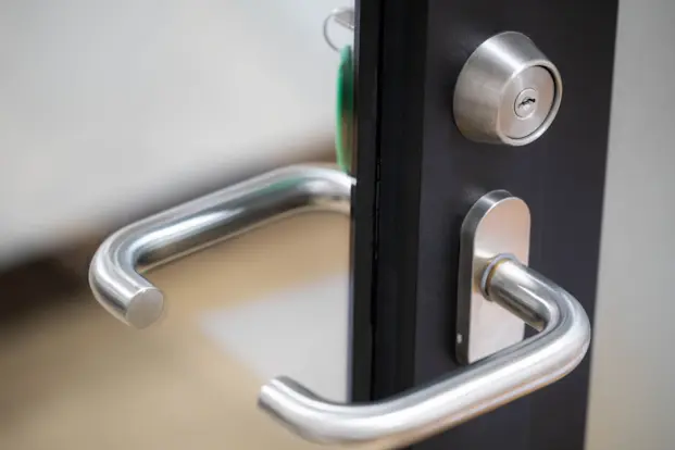 Manilla de acero inoxidable y cerrojo en puerta, cambio de bombín y refuerzo con cerrajero